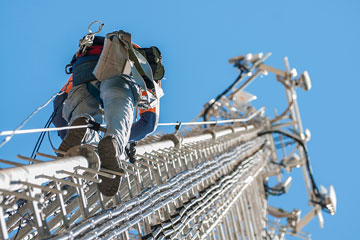 a worker climbing an antenna tower